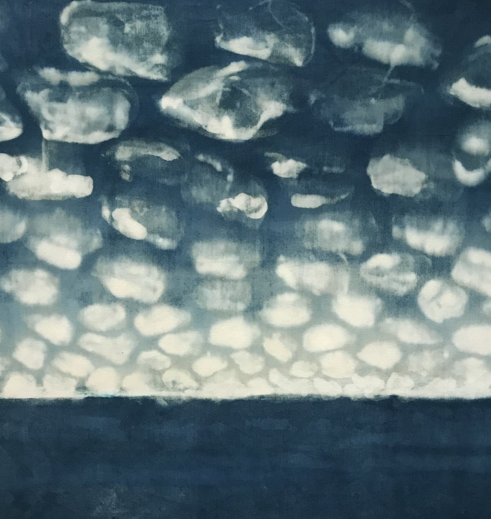 Rows of pale cloud-like shapes lifted out of a deep indigo ground above a dark horizon band. Untitled, 2022 by Emma Hurst.